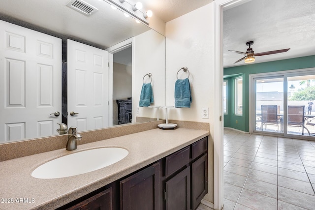 bathroom with tile patterned flooring, visible vents, ceiling fan, and vanity