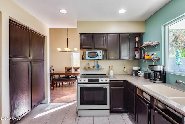 kitchen with a sink, stainless steel range with electric cooktop, light countertops, open shelves, and decorative light fixtures