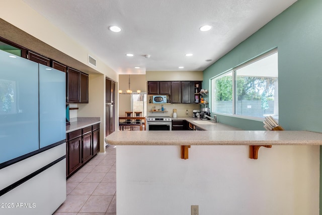 kitchen featuring a breakfast bar area, visible vents, light countertops, stainless steel electric range oven, and open shelves