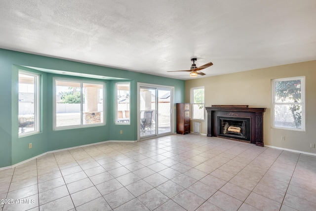 unfurnished living room featuring ceiling fan, a fireplace, a textured ceiling, and light tile patterned floors