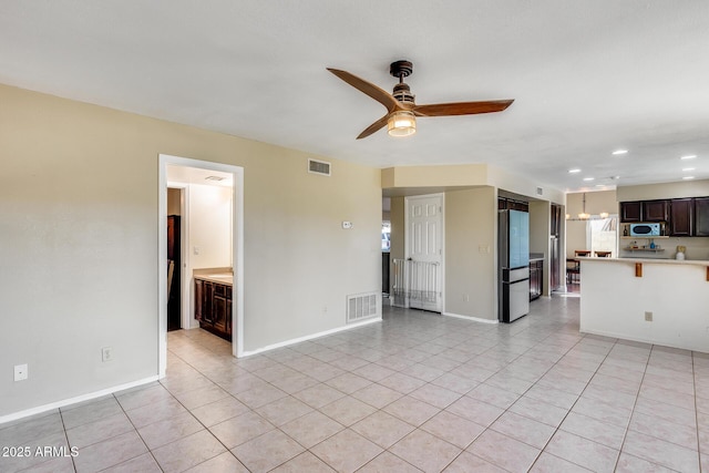 unfurnished living room featuring light tile patterned floors, ceiling fan, visible vents, and baseboards