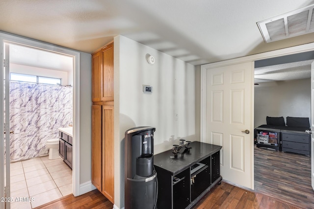 kitchen with visible vents, brown cabinets, and wood finished floors