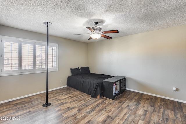 bedroom featuring a ceiling fan, dark wood-style flooring, a textured ceiling, and baseboards