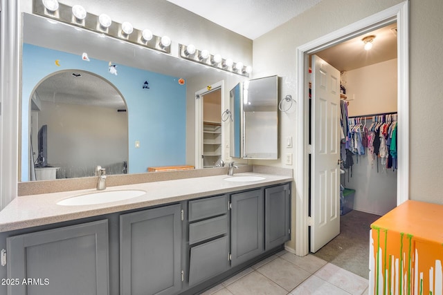 bathroom with double vanity, tile patterned flooring, and a sink