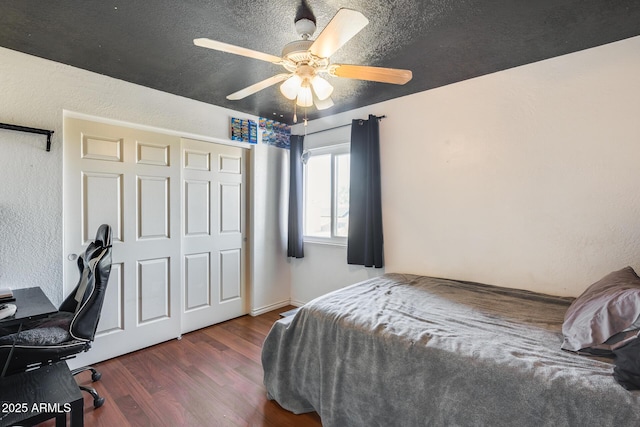 bedroom with a textured ceiling, a textured wall, ceiling fan, a closet, and dark wood-style floors