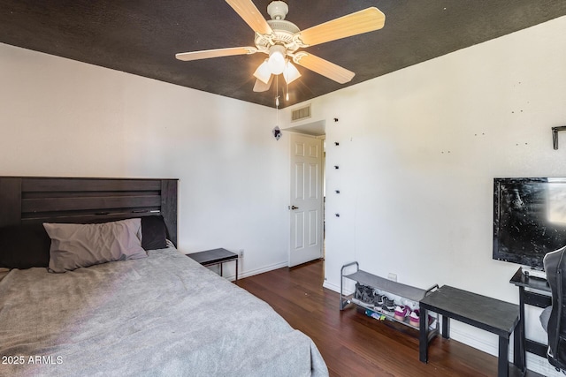 bedroom with ceiling fan, dark wood finished floors, visible vents, and baseboards