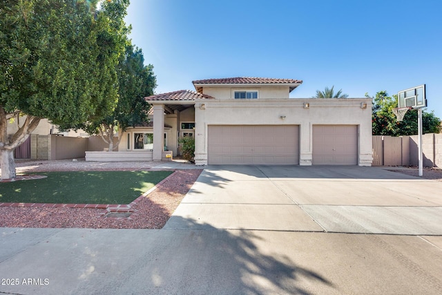 mediterranean / spanish-style house featuring an attached garage, fence, a tile roof, driveway, and stucco siding