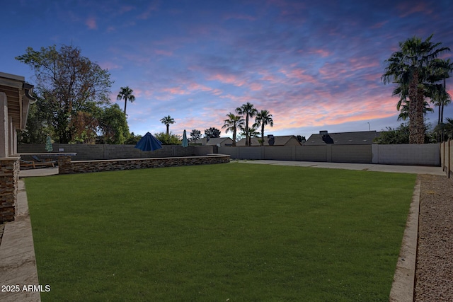 yard at dusk with a fenced backyard