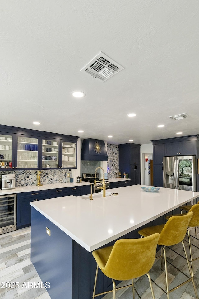 1656 W Meseto Cir, Mesa, AZ 85202 - kitchen featuring beverage cooler, a sink, blue cabinets, a kitchen breakfast bar, and recessed lighting