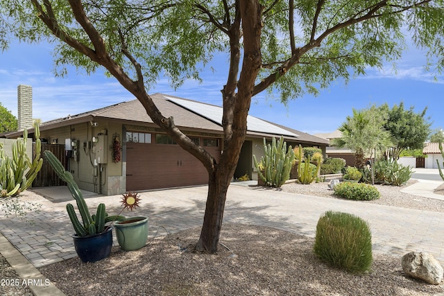 1656 W Meseto Cir, Mesa, AZ 85202 - view of front facade with an attached garage, solar panels, driveway, a chimney, and roof with shingles
