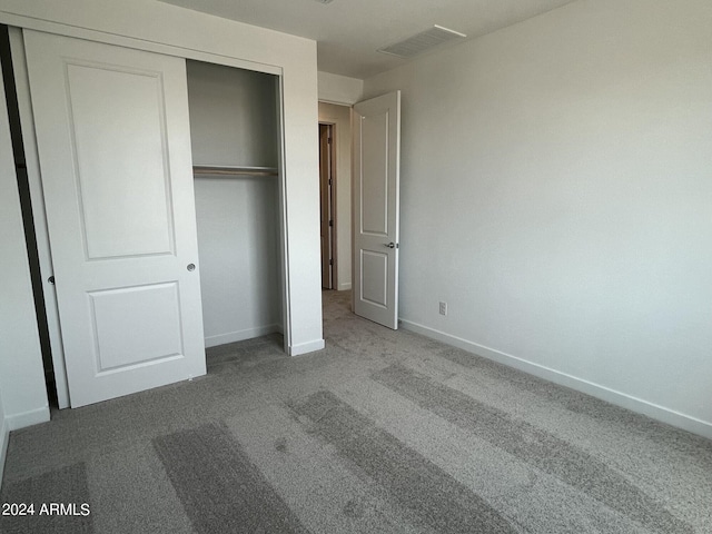 unfurnished bedroom featuring carpet floors and a closet