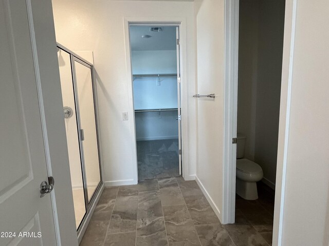 bathroom with tile patterned floors, toilet, and walk in shower