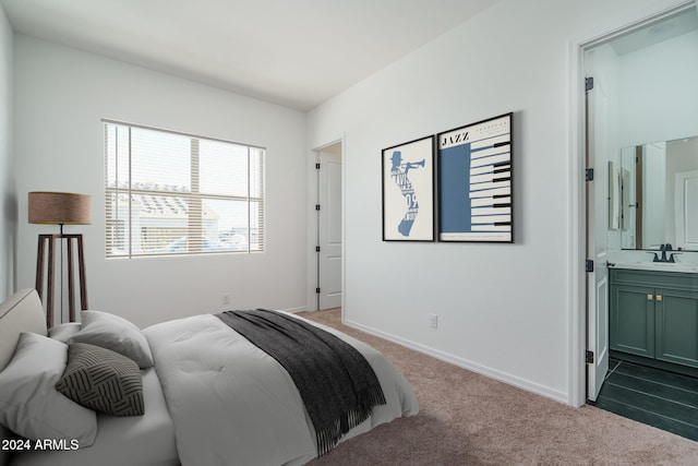 bedroom featuring light carpet, ensuite bath, and sink