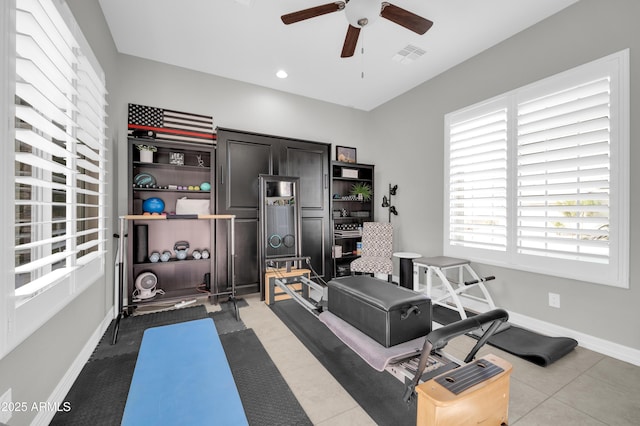 exercise area with tile patterned floors and ceiling fan