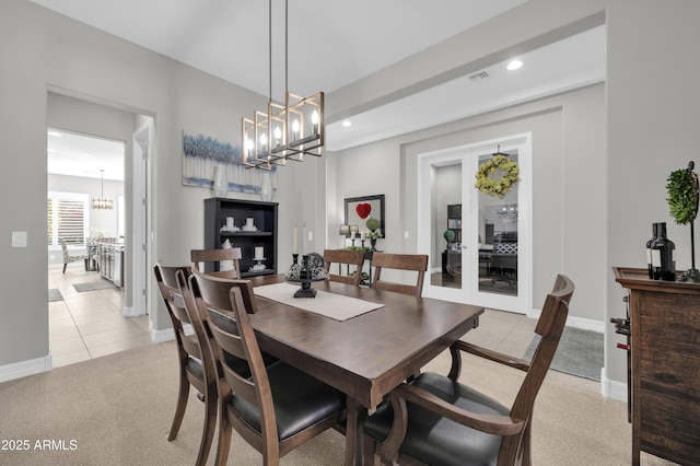 dining area featuring an inviting chandelier and light colored carpet