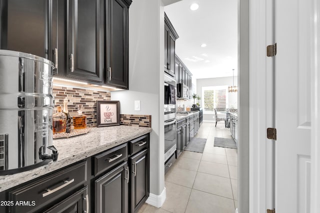 kitchen with light stone counters, light tile patterned floors, and backsplash