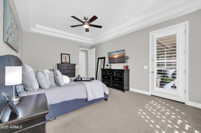 bedroom with ceiling fan, a tray ceiling, and carpet floors