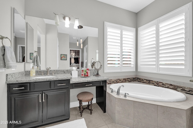 bathroom with tile patterned floors, vanity, and tiled tub