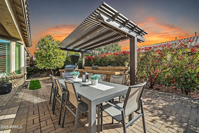 patio terrace at dusk with a grill and a pergola