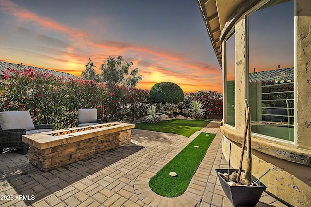 patio terrace at dusk featuring a fire pit