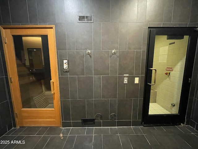 bathroom with tile patterned flooring and tile walls