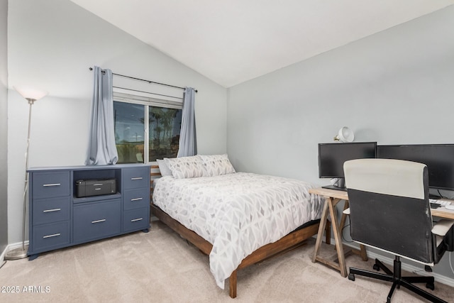 bedroom featuring light colored carpet, vaulted ceiling, and a desk