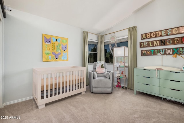 bedroom featuring lofted ceiling, carpet flooring, and a crib