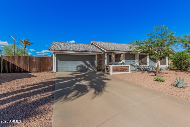 ranch-style home featuring driveway, an attached garage, fence, and a tile roof