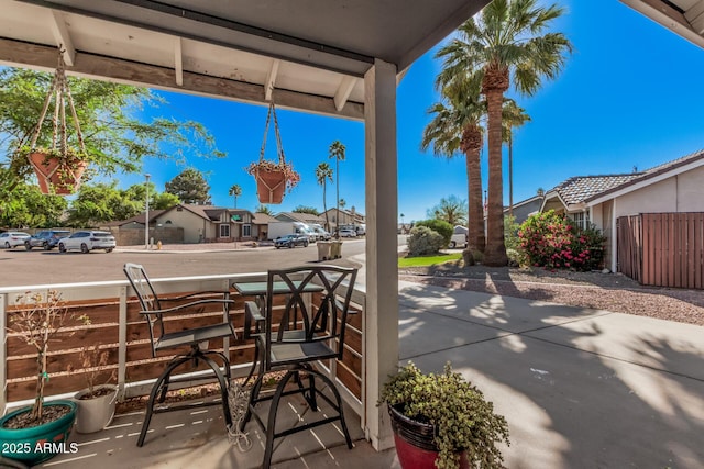 view of patio with a residential view, covered porch, and fence