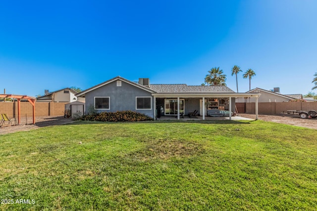 back of property with a patio, a storage shed, an outbuilding, central AC unit, and stucco siding