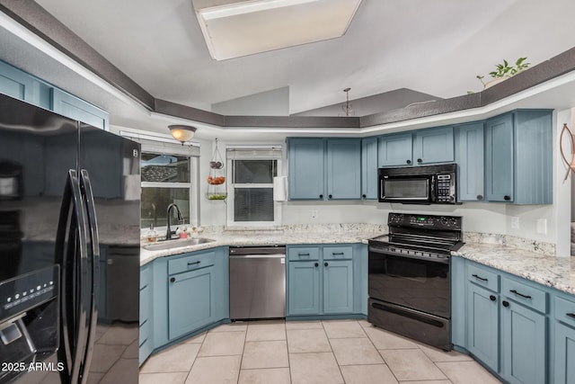 kitchen featuring black appliances, a sink, blue cabinets, light tile patterned floors, and vaulted ceiling
