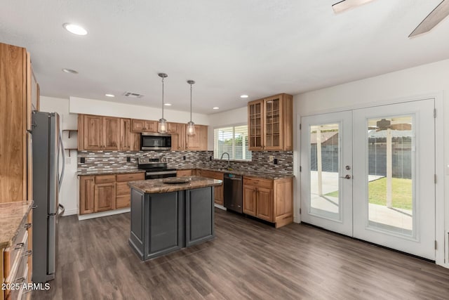 kitchen with pendant lighting, french doors, decorative backsplash, a kitchen island, and stainless steel appliances