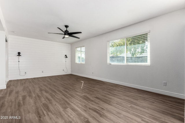 empty room with ceiling fan and dark hardwood / wood-style flooring