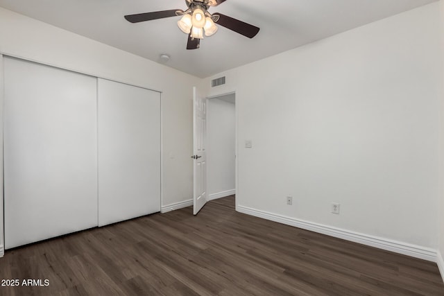 unfurnished bedroom with ceiling fan, dark hardwood / wood-style floors, and a closet