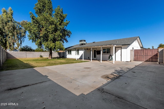 rear view of property featuring a lawn, a patio area, and central air condition unit