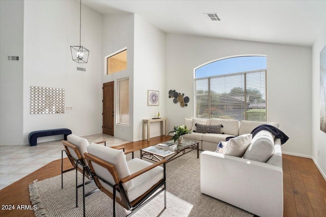 living room with a chandelier, high vaulted ceiling, and wood-type flooring