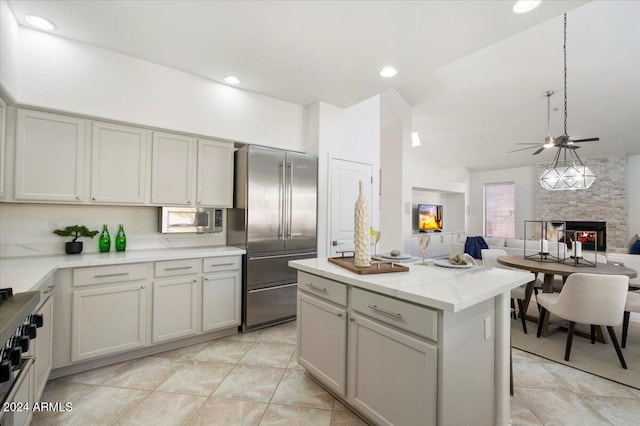 kitchen featuring gray cabinets, high end refrigerator, a large fireplace, and ceiling fan