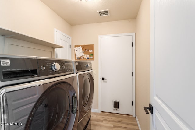 washroom featuring separate washer and dryer and light hardwood / wood-style flooring