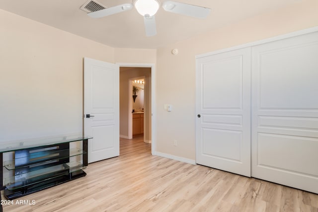 bedroom featuring light hardwood / wood-style floors, ceiling fan, and a closet