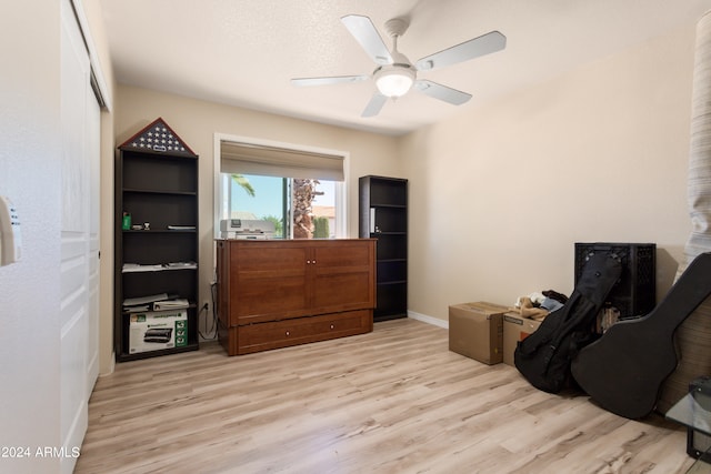 living area featuring ceiling fan, a textured ceiling, and light wood-type flooring