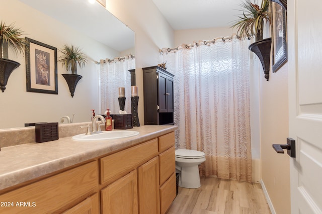 full bathroom with shower / bath combo with shower curtain, hardwood / wood-style flooring, vanity, and toilet