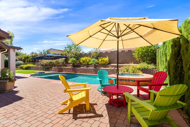 view of patio / terrace featuring a swimming pool with hot tub