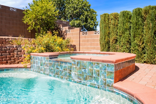 view of pool featuring an in ground hot tub and pool water feature