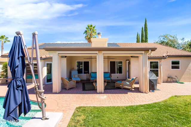 rear view of property featuring a lawn, a patio, a pool, and an outdoor hangout area