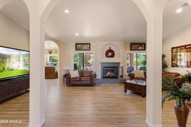 living room featuring light hardwood / wood-style flooring and a tile fireplace