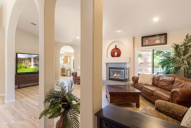 living room featuring light hardwood / wood-style floors and a tile fireplace