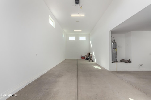 garage with baseboards and electric water heater