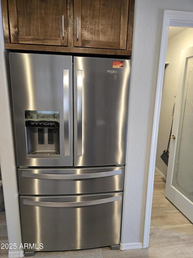 9016 W Fossil Creek Rd, Pine, AZ 85544 - detailed view of stainless steel fridge, baseboards, light wood finished floors, and dark brown cabinetry