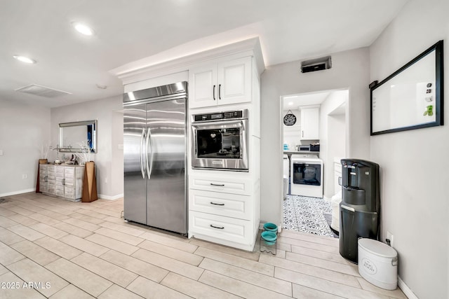 6215 E Surrey Ave, Scottsdale, AZ 85254 - kitchen featuring stainless steel appliances, white cabinets, washer / clothes dryer, and recessed lighting