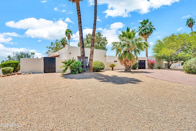 6215 E Surrey Ave, Scottsdale, AZ 85254 - view of front facade featuring stucco siding, a gate, and driveway